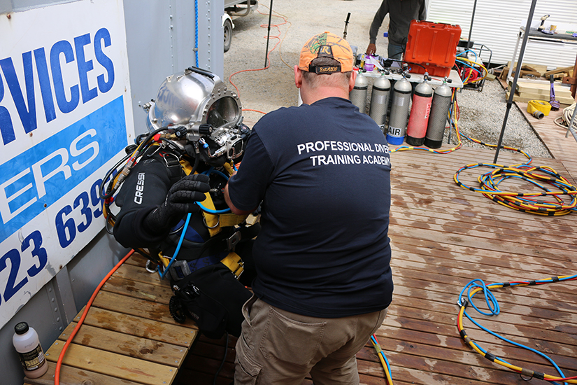 Occupational diver preparing to enter dive training tank