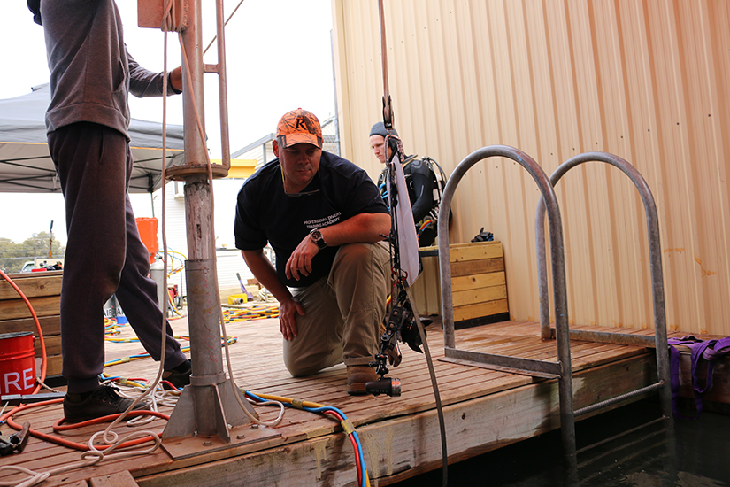 Occupationla diving student lowering equipment into tank