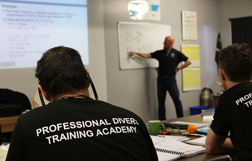 Dive supervisor trainer and students doing calculations