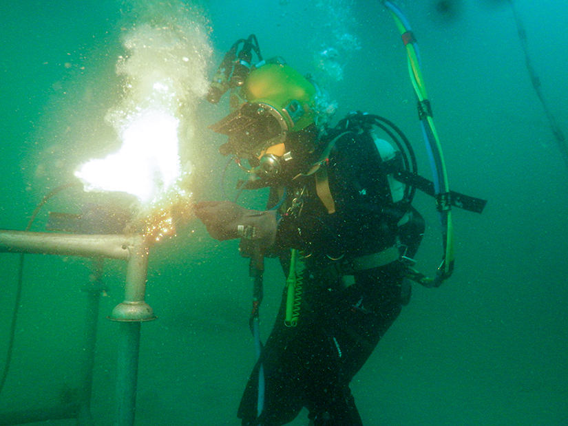 Commercial diving student in underwater welding task